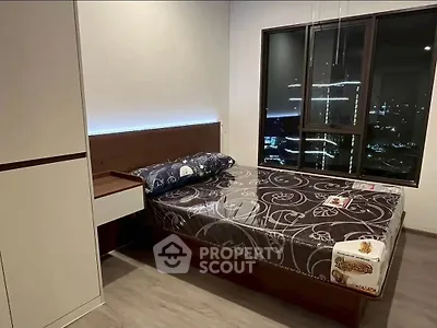 Modern bedroom with city view, featuring sleek furniture and ambient lighting.