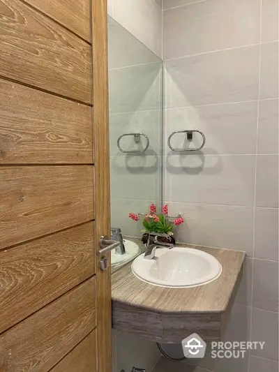 Modern bathroom with stylish wooden door and elegant sink design