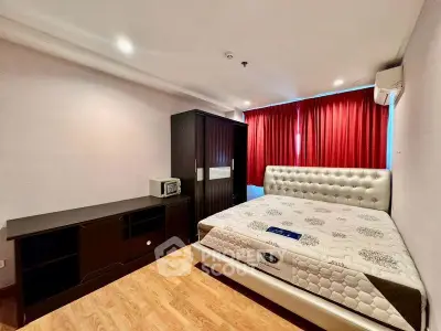Spacious bedroom with modern furniture and red curtains in a stylish apartment.