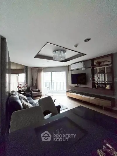 Spacious modern living room with elegant chandelier and balcony view