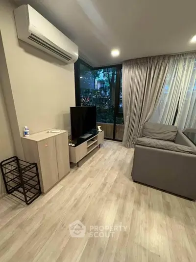 Modern living room with large windows and sleek furniture in a cozy apartment.