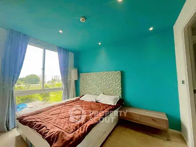 Bright bedroom with teal walls and large window offering scenic views.