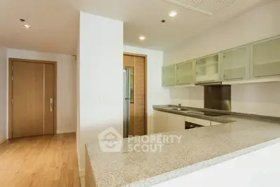 Modern kitchen with sleek countertops and ample storage in a contemporary apartment.