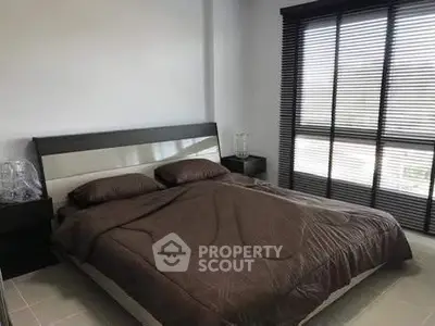 Modern bedroom with large window and stylish blinds in a contemporary apartment.
