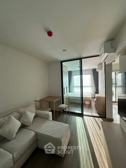 Modern living room with natural light and cozy furniture in a stylish apartment.