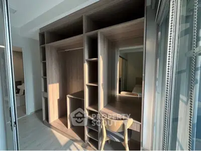 Modern built-in wooden wardrobe with desk in a bright room, perfect for maximizing space and functionality.