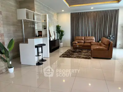 Spacious modern living room with elegant decor and leather sofas, perfect for relaxation and entertainment.
