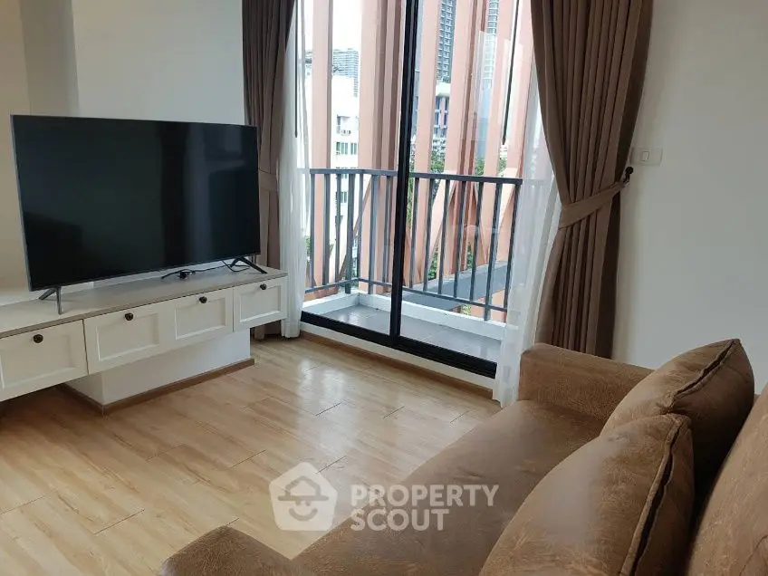 Modern living room with large TV and balcony view in urban apartment