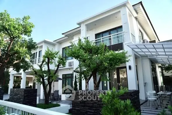 Modern two-story white house with lush greenery and stylish architecture