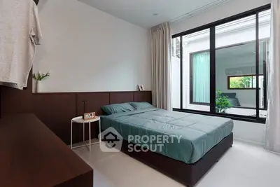 Modern bedroom with large window and minimalist decor, featuring a cozy bed and sleek furnishings.