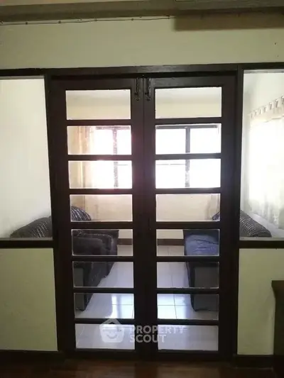 Spacious living room with glass doors and cozy seating area.