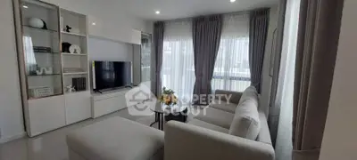 Modern living room with sleek furniture and large windows for natural light.