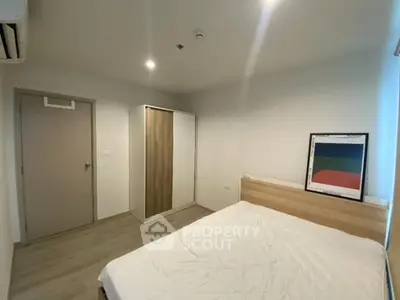 Modern minimalist bedroom with wooden flooring and stylish wardrobe