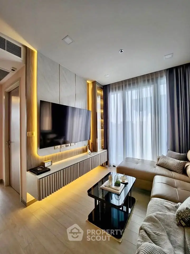 Modern living room with sleek design, large TV, and cozy seating area, perfect for relaxation and entertainment.