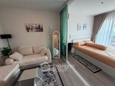 Modern studio apartment with cozy living area and bedroom, featuring stylish decor and natural light.