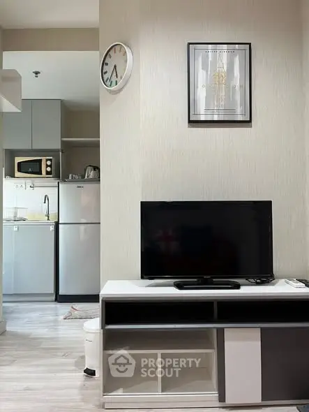 Modern living room with sleek TV stand and kitchen view