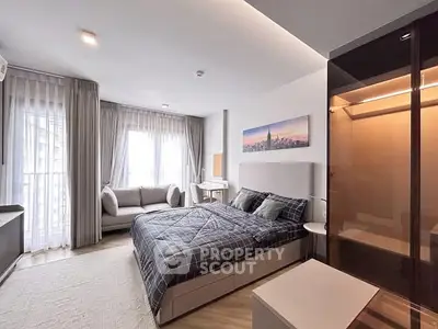 Modern bedroom with stylish decor and natural light, featuring a cozy bed and elegant furnishings.