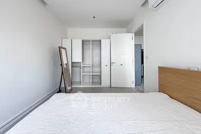 Spacious bedroom with modern wardrobe and air conditioning in a minimalist design.