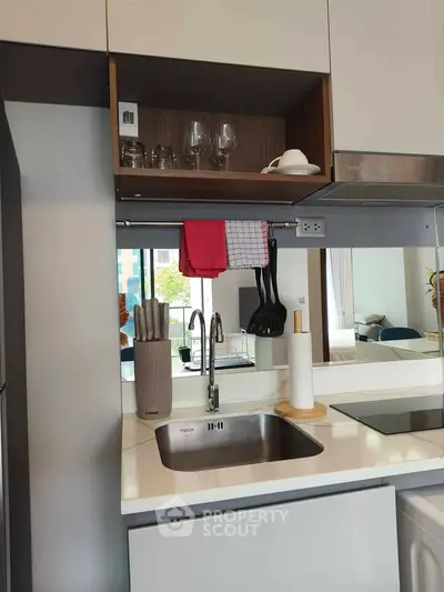 Modern kitchen with sleek design, featuring a built-in sink, induction cooktop, and stylish cabinetry.