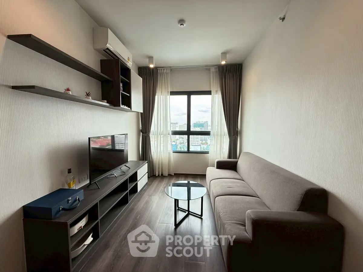 Modern living room with sleek furniture and city view from window, perfect for urban living.