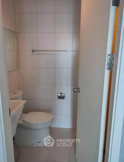 Modern bathroom with sleek white tiles and contemporary fixtures.