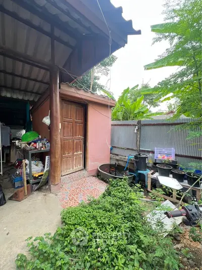 Charming rustic exterior with lush greenery and cozy patio area, perfect for relaxation and outdoor activities.