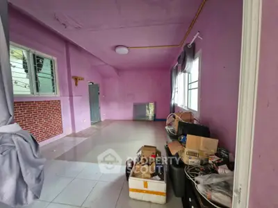 Spacious living room with vibrant purple walls and large windows, ideal for creative interior design.