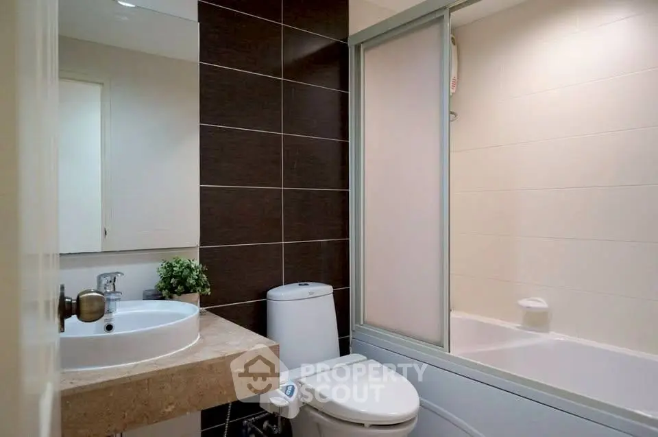 Modern bathroom with sleek design, featuring a bathtub and elegant fixtures.