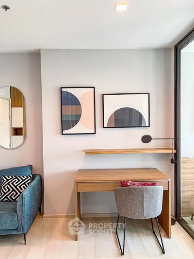 Modern living room with stylish furniture and wall art, featuring a cozy study nook.
