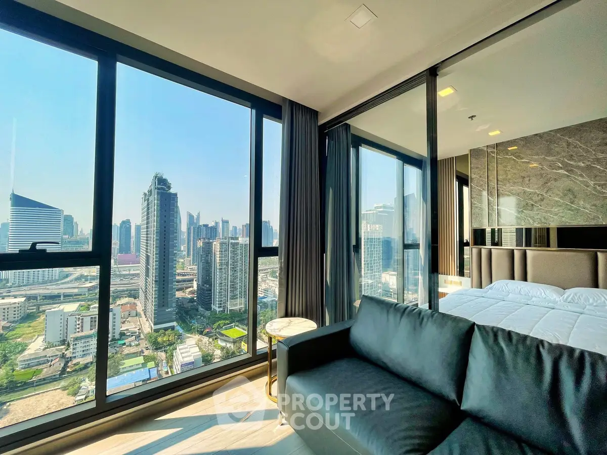 Luxurious corner unit with stunning city view, featuring modern living room and bedroom with floor-to-ceiling windows.