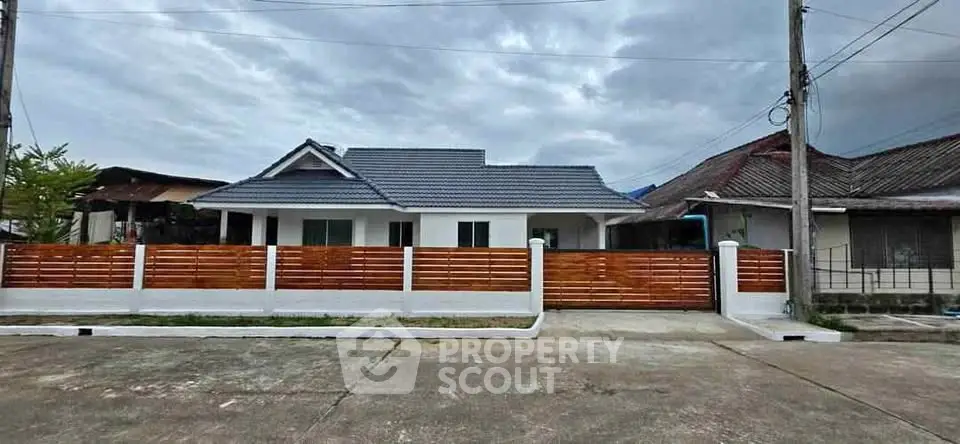Charming single-story house with modern fence and spacious driveway in a serene neighborhood.