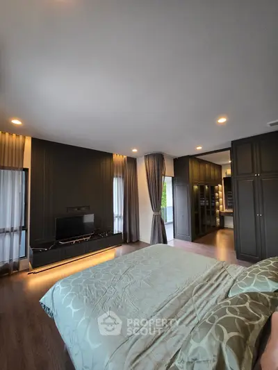 Luxurious bedroom with elegant decor and spacious walk-in closet, featuring modern lighting and stylish furnishings.