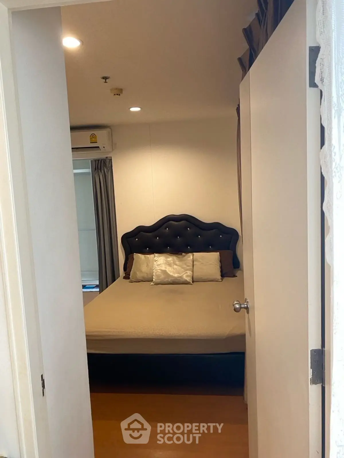 Cozy bedroom with elegant headboard and soft lighting, perfect for relaxation and comfort.