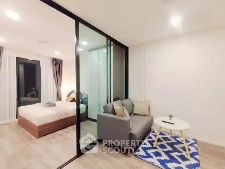 Modern studio apartment with glass partition, cozy living area, and stylish decor.