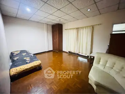 Spacious bedroom with parquet flooring and cozy furnishings