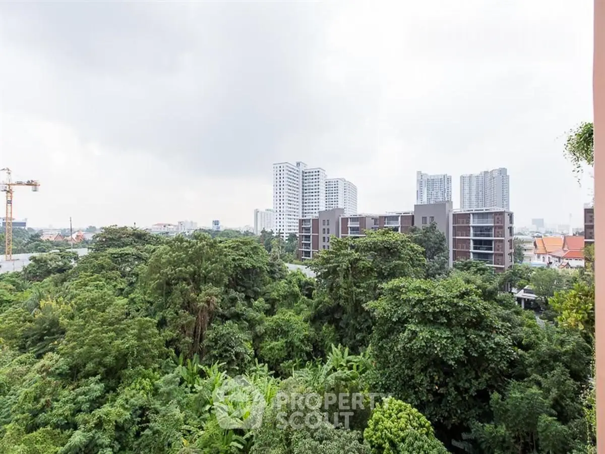 Stunning cityscape view with lush greenery and modern high-rise buildings.