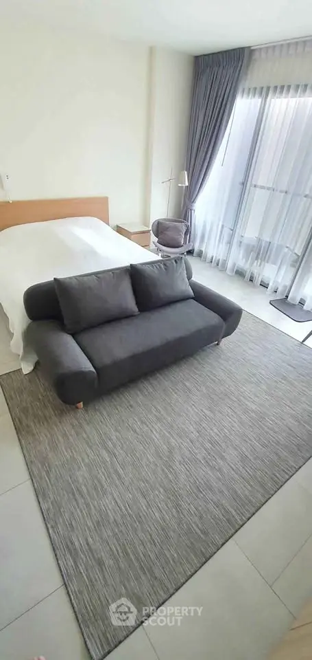 Modern bedroom with stylish gray sofa and large window view