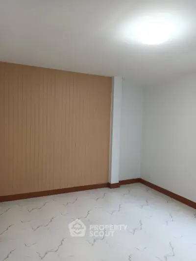 Minimalist empty room with modern flooring and accent wall