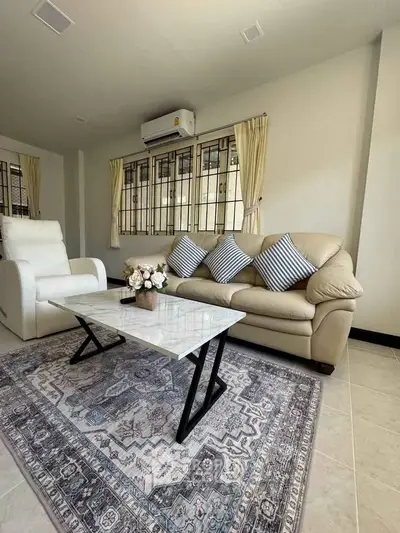 Elegant living room with cozy sofa, stylish coffee table, and chic decor in a bright, airy space.