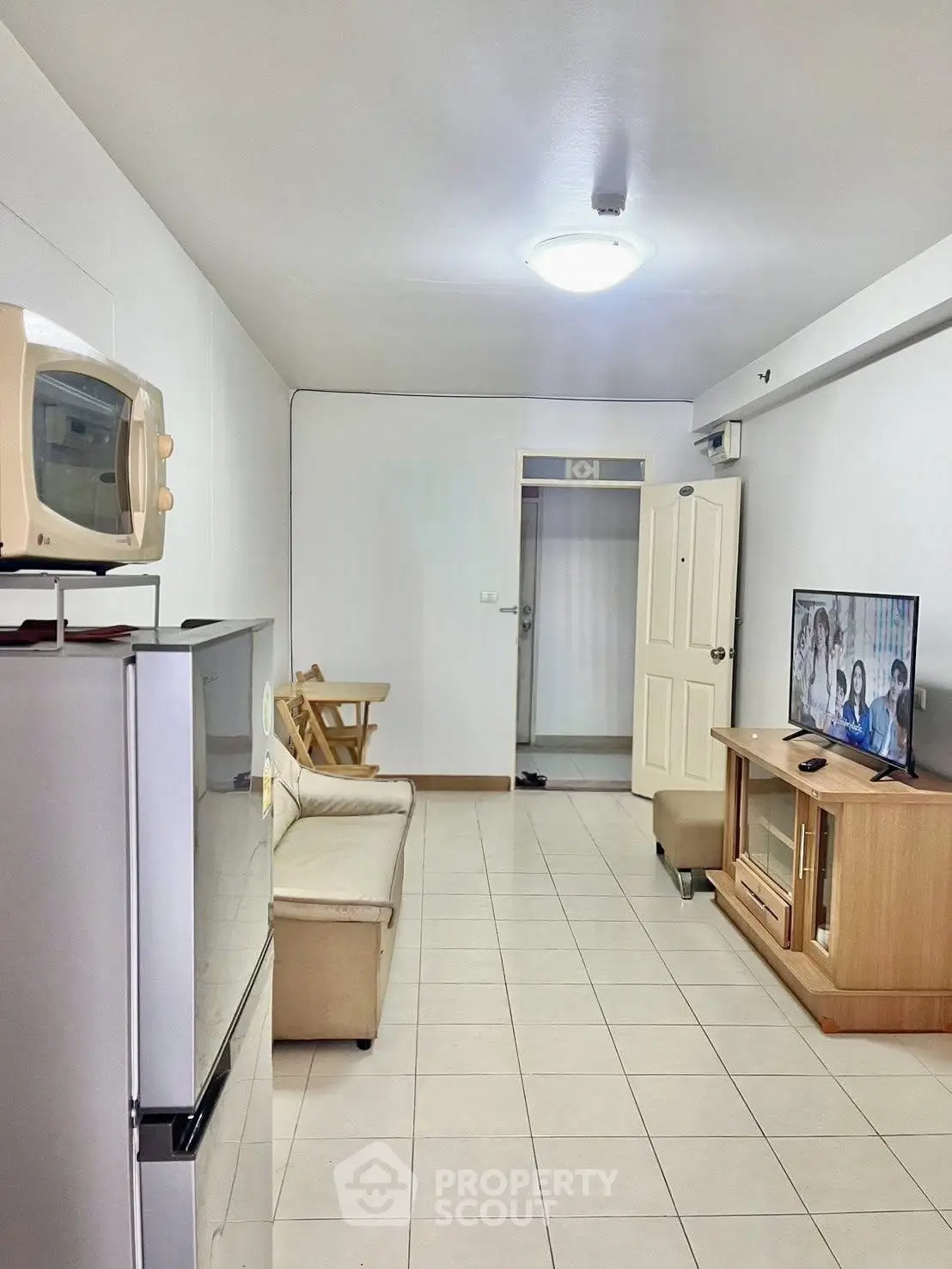 Cozy living room with modern appliances and comfortable seating in a bright apartment.