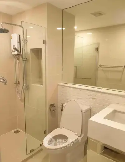 Modern bathroom with glass shower and sleek fixtures in a contemporary apartment.