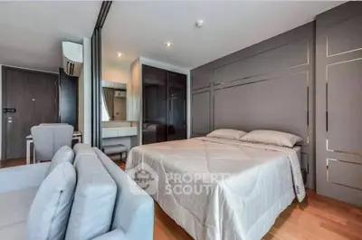 Modern bedroom with stylish decor and cozy seating area in a contemporary apartment.