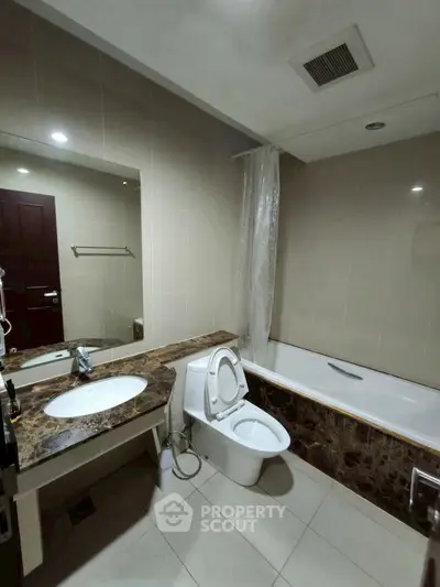 Modern bathroom with marble countertop and bathtub in elegant real estate property.