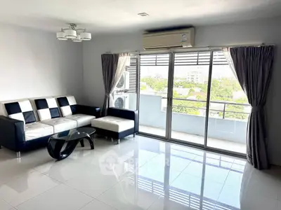 Spacious modern living room with large windows and balcony view