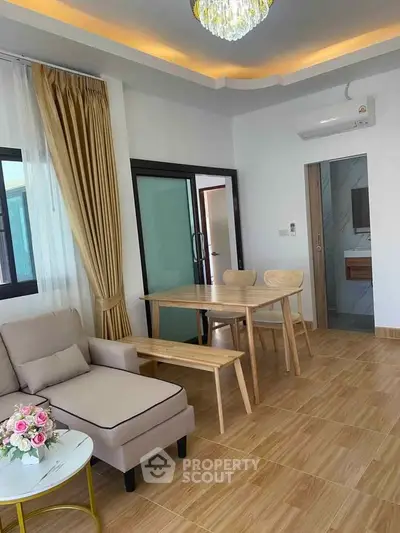 Modern living room with elegant decor and dining area, featuring cozy seating and stylish lighting.