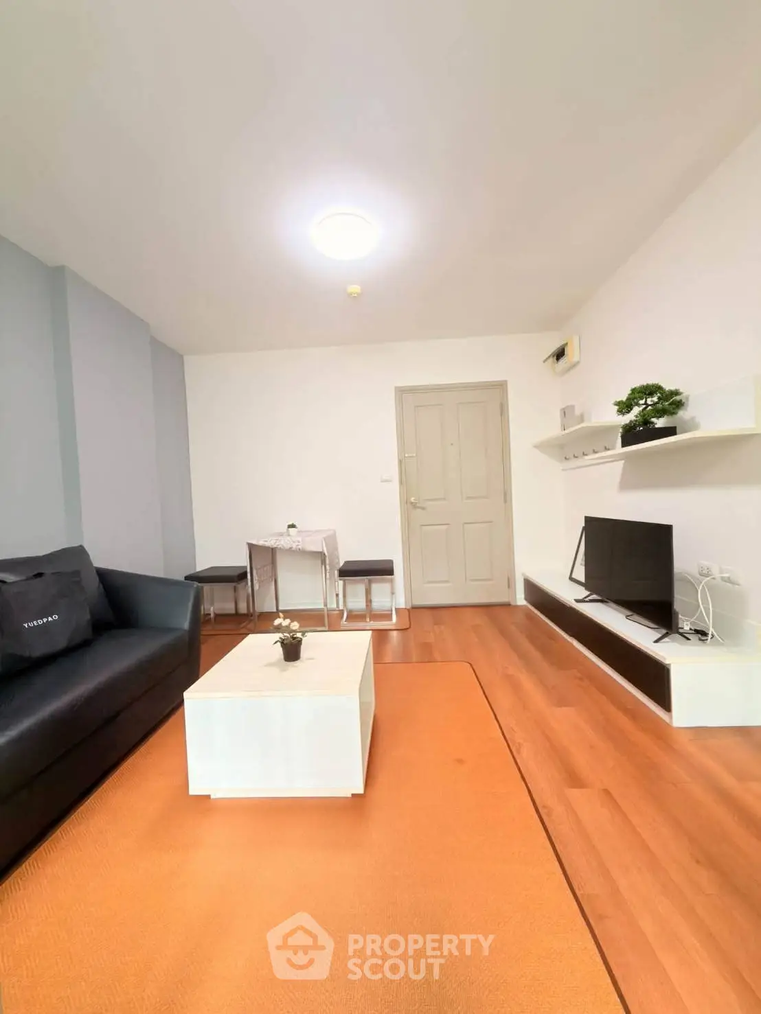 Modern living room with sleek furniture and wooden flooring, perfect for cozy gatherings.