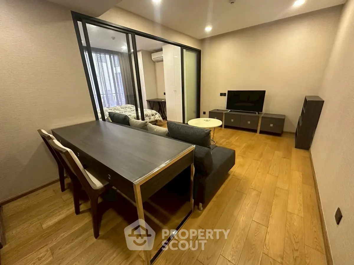 Modern living room with wooden flooring and stylish furniture in a cozy apartment setting.