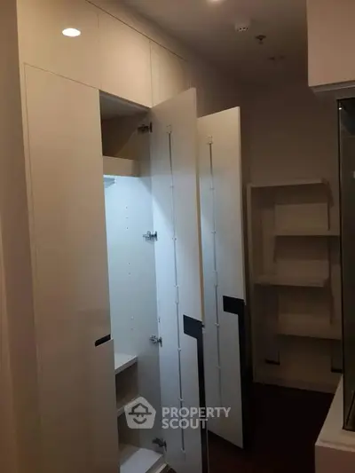 Modern storage space with sleek white cabinets and open shelving