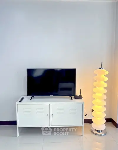 Modern living room with sleek TV stand and unique floor lamp