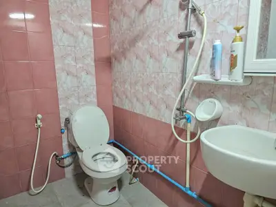 Charming bathroom with pink tiles and modern fixtures, ideal for cozy living.